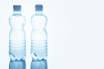 Blue bottles of pure still water against white background