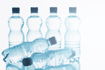Blue bottles of pure still water against white background