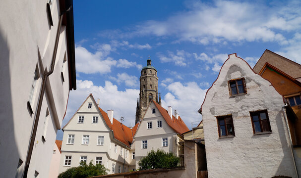 a beautiful ancient Bavarian town of Noerdlingen with its half-timbered houses and Saint George's Church's steeple called "Daniel" in the background on a summer day (Bavaria, Germany)	