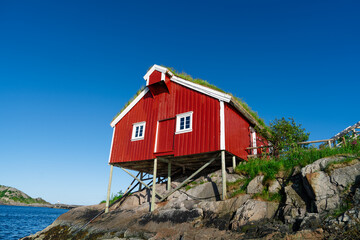 Fototapeta na wymiar Norway. Fishermans red rorbu cottage in the Lofoten Islands. Typical Scandinavian Fishermans house. now days popular tourist apartments, cottages, rent houses.