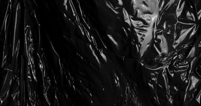 Embark on a journey through the depths of a beautifully dark plastic abstract background, where glossy polyethylene texture adds alluring touch akin to cosmic black hole, creating textual elements.