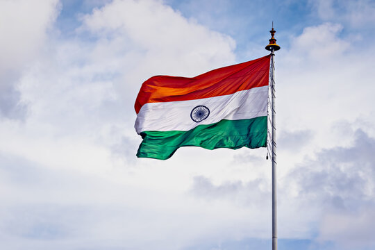 Indian National Flag , flying high in the sky on a beautiful , clear blue sky background
