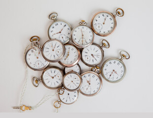 Group of old pocket clocks against white background