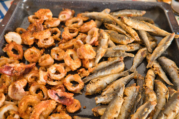 fried calamari and anchovies on a tray