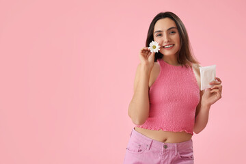 Young woman with menstrual pad and daisy flower on pink background