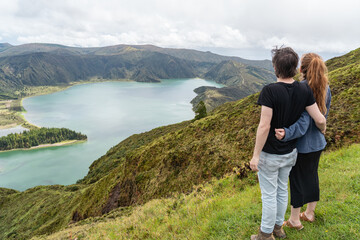 Fototapeta na wymiar Couple looking at the incredible, enchanting view over the lagoa do Fogo in the Azores. 