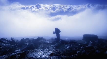 Mountaineering, sport, active lifestyle concept. Male silhouette standing on the top of the mountain