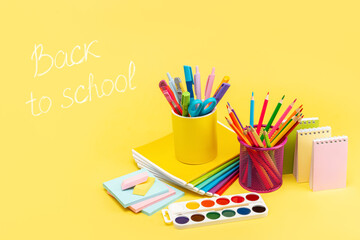 Bright multicolored stationery for school pencils, pens, rulers, paints, notepad, eraser on a...