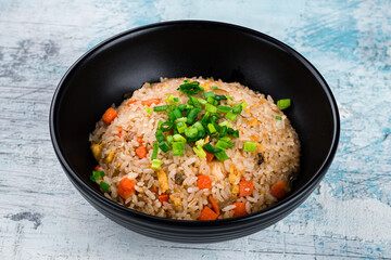 Fried rice with chicken, carrots, onions, soy sauce, sesame seeds and green onions.