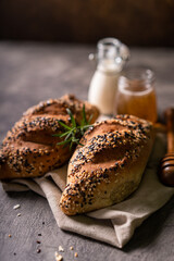 Fresh homemade bread whole wheat baguette white milk and honey on rustic wooden board and abstract table. Sourdough bread
