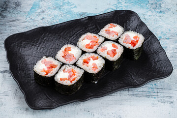 Sushi maki rolls with shrimp, cream cheese and red sweet pepper in a plate.