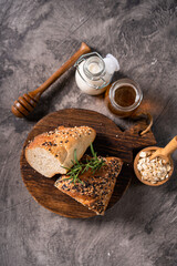 Fresh homemade bread whole wheat baguette white milk and honey on rustic wooden board and abstract table. Sourdough bread

