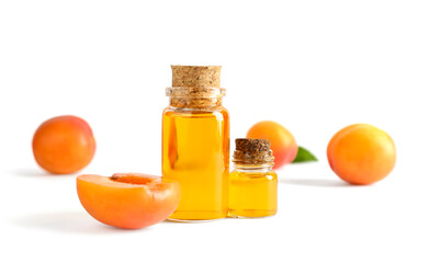 Bottles of essential oil and ripe apricots isolated on white background
