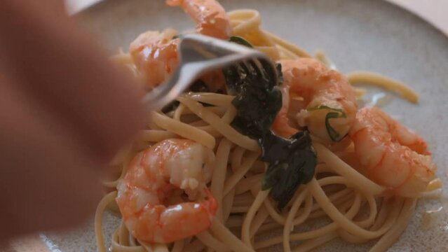 Woman placing garlic prawn spaghetti on a platter