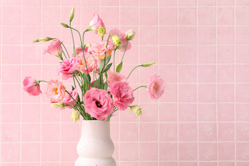 Vase with beautiful pink eustoma flowers on light tile background