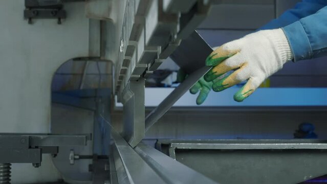 Close up of worker pressing metal at workshop. Creative. Sheet metal hydraulic CNC press brake machine.