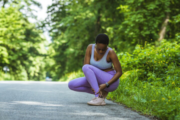 Fitness, pain and black woman with a foot injury, medical emergency and accident after running. Anatomy, symptom and African runner with muscle inflammation in feet after street cardio