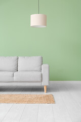 Interior of living room with sofa near green wall