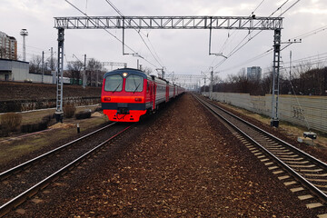 Modern urban transportation on electric locomotives to transport passengers via trains on railway. The motion of vehicle on tracks and travel to countryside. Wide angle