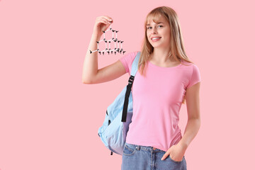 Female student with molecular model on pink background