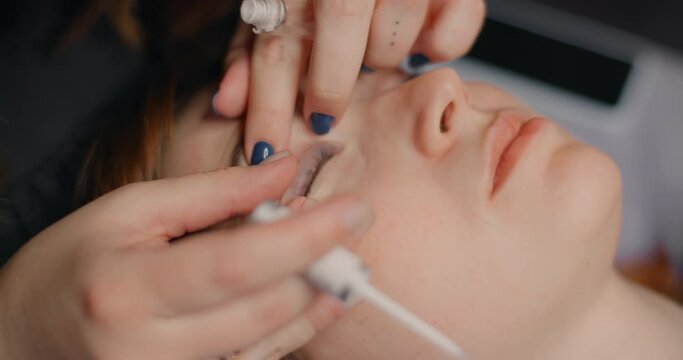 Lashmaker does the eyelash lamination procedure for the client in the beauty salon, cosmetic services, beauty care procedures, 4k 60p Prores HQ