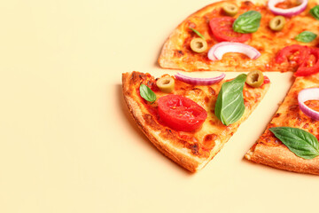 Tasty pizza with olives, tomatoes and basil on yellow background