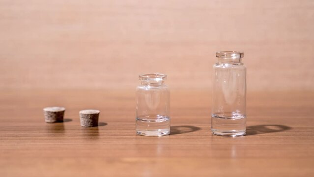 Glass flacons are filled with transparent liquid