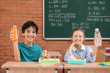 Little pupils having lunch in classroom