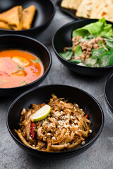 Rice noodle pad thai with squid, Tom yum soup with chicken, salad Laap Gai with minced chicken, Naan flatbread and omelette.