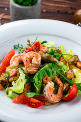 Green salad of shrimp, mussels, cherry tomatoes oranges, grapefruits, capers, lettuce and arugula.