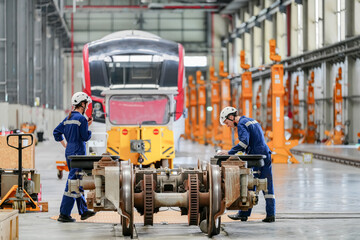Engineers inspecting locomotive in railway engineering facility