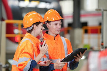 Engineers inspecting locomotive in railway engineering facility