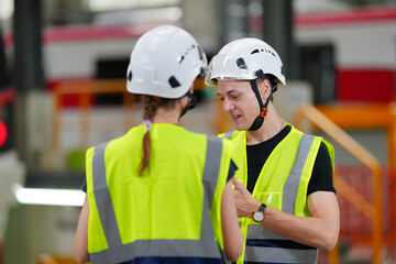 Engineers inspecting locomotive in railway engineering facility