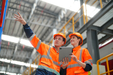 Engineers inspecting locomotive in railway engineering facility
