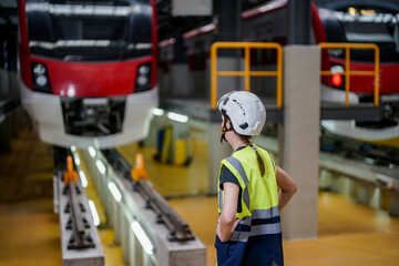 Engineers inspecting locomotive in railway engineering facility