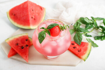 Board with glass of tasty watermelon cocktail and mint on white background