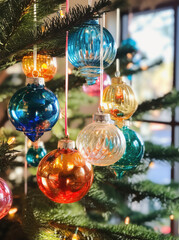 Colourful glass Christmas ornaments on a pine tree branch