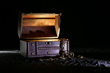 Decorative box with jewellery and glowing light on black background