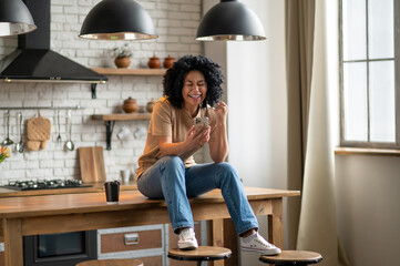 Young woman in jeans and beige tshirt in the kitchen