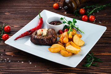 Beef fillet steak with Rustic fried potato wedges, onions, chili peppers, cherry tomatoes and sauce.