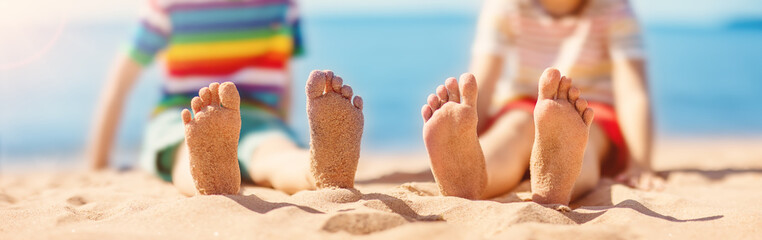 Children sitting on the sand on the beach near the sea. - 624525469