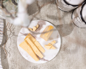 flat lay. Sliced cheese top view on the board and a light background under gray granite