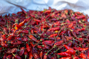 Ultra Close Up of a Bunch of Ripe Red Hot Chili Peppers on a Stall in Colorful Market 