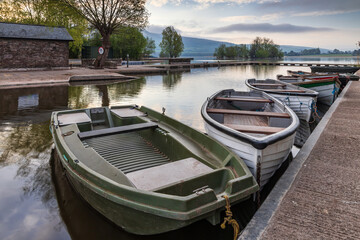 Obraz premium Boats tied to the jetty at Llangorse Lake, Brecon Beacons National Park. Taken just after sunrise. 