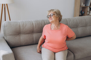 Senior lady feeling muscles pain attack, holding back, having problem with standing up. Elderly woman suffering from chronic backache, kidney disease, lumbar osteochondrosis, inflammation