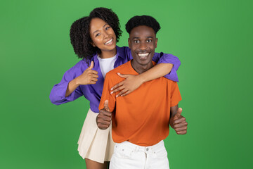 Glad millennial african american lady hug boyfriend in casual, show thumb up, enjoy date