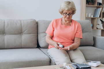 Sick older woman take care for health, using sphygmomanometer for measure blood pressure, pulse and...