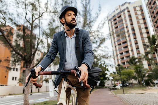 A modern urban commuter, the businessman embraces eco-friendly transportation, cycling through the city's avenues