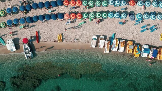 4k 25fps footage of Grotticelle beach near Capo Vaticano in the Calabria region. You notice the crystal clear Caribbean sea, the bathers and the colored umbrellas