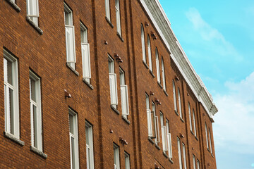 Fototapeta na wymiar old building windows and brick wall roof corner on cloudy sky